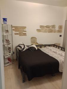 um quarto com uma cama com um cobertor preto em pesa apartment B&B em Ascoli Piceno