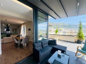 a living room with a couch and a dining room at SEA VIEW LUXURY PENTHOUSE in Vlorë