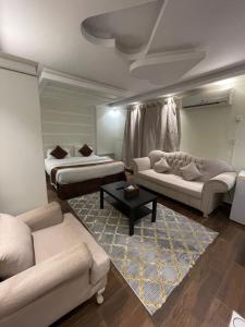 een woonkamer met 2 bedden en een bank bij شاليهات ليالينا in Muhayil