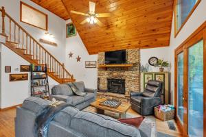 uma sala de estar com sofás e uma lareira em Lakefront Cabin Bordering Nat Park with Hot Tub! cabin em Turtletown