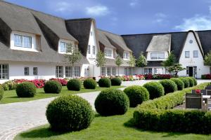 eine Reihe von Häusern mit Büschen und Blumen in der Unterkunft Severin's Resort & Spa in Keitum