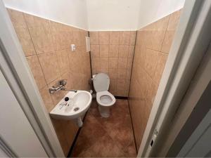 a small bathroom with a toilet and a sink at Warsaw Lux Rooms in Warsaw
