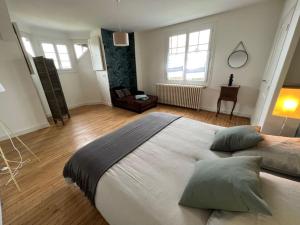 a bedroom with a large bed with pillows on it at Belle villa Périgourdine avec piscine in Bergerac