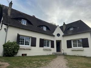a white house with black shuttered windows and a driveway at Belle villa Périgourdine avec piscine in Bergerac