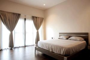 a bedroom with a large bed and large windows at Modern Townhouse near Beach in Accra