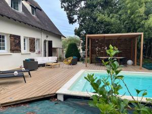 a wooden deck next to a house with a pool at Belle villa Périgourdine avec piscine in Bergerac