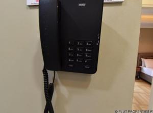 Un téléphone noir est suspendu sur un mur dans l'établissement ACACUS ROYAL, à Kigali