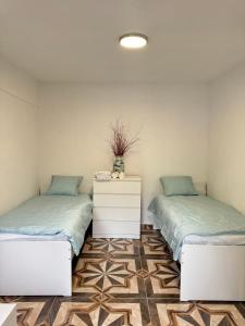 two beds sitting next to each other in a room at 布拉格城堡公寓 in Rudná