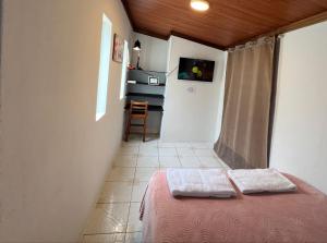 Cette petite chambre comprend un lit et une cuisine. dans l'établissement Tiny apartment in the city rooftop terrace, à Baños