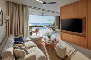 a living room with a couch and a flat screen tv at Mandarin Oriental, Costa Navarino in Pylos