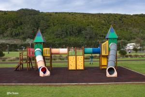 een speeltuin in een park met twee speeltoestellen bij Alojamento Vila Flor in Praia da Vitória