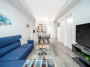 a living room with a blue couch and a table at Modern 1BR Condo - King bed - Cityscape Views in Kitchener