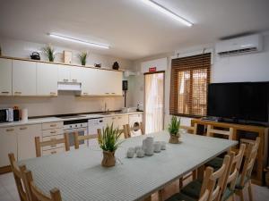 a kitchen with a table with chairs and a television at Villalfredo Ducal in Pastrana