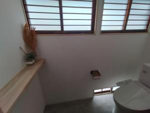 a bathroom with a toilet and two windows at 敷島旅館 in Saijo +32 photos