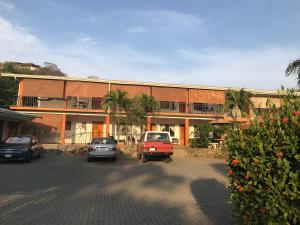 een groot gebouw met auto's geparkeerd op een parkeerplaats bij Bolimar at Playa Hermosa, Guanacaste in Playa Hermosa