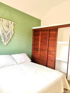 1 dormitorio con cama y pared verde en Sweet home Ixtapa comfort en Ixtapa