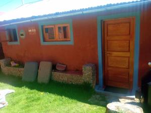 a house with a door and a bench in front of it at TITICACA'S SALA UTA in Puno