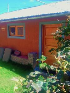 プーノにあるTITICACA'S SALA UTAの赤いソファ付きのオレンジハウスのドア