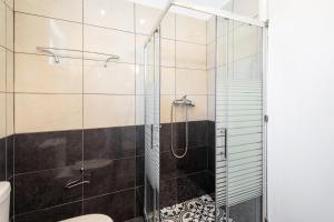 un bagno con doccia con porta in vetro di Kassiani-Sofia Cottage a Gouviá Altre 17 foto
