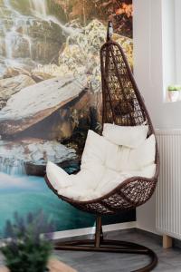 a wicker chair in a room with a painting at Kassiani-Sofia Cottage 1,5 km from beach in Gouvia