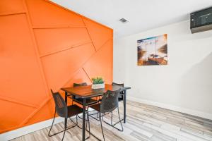 タンパにあるTampa Bayshore Home 6248のオレンジ色の壁の客室で、テーブルと椅子が備わります。