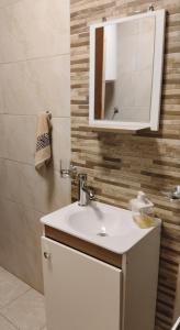 een badkamer met een wastafel en een spiegel bij Lugar tranquilo in Colonia del Sacramento