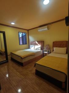 a hotel room with two beds and a mirror at Permata Beach Chalet in Kampong Juara