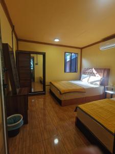 a hotel room with two beds and a mirror at Permata Beach Chalet in Kampong Juara