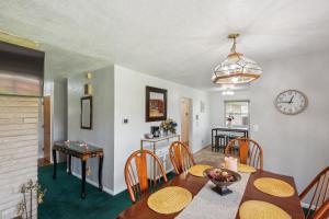 uma sala de jantar com mesa e cadeiras e um relógio em Elkhart Haven- Cozy Family Retreat home em Elkhart
