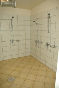 a bathroom with two showers and a tiled floor at Remniku Holiday Centre in Remniku