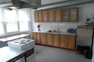 a kitchen with wooden cabinets and a white stove top oven at Remniku Holiday Centre in Remniku