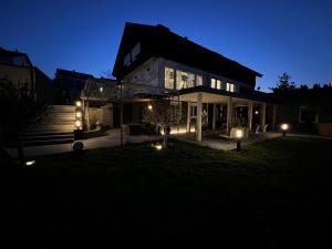 una casa con luces en el patio por la noche en Ferienwohnung BodenseeSuite in Friedrichshafen en Friedrichshafen