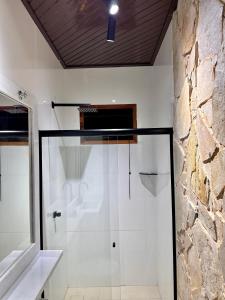 a glass shower in a bathroom with a stone wall at Apartamento coração de Santarém in Santarém +41 photos