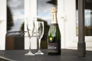 - une bouteille de champagne et 2 verres à vin sur une table dans l'établissement Stunning House in Clanfield, à Clanfield