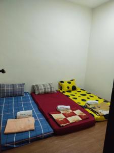 1 Schlafzimmer mit 2 Einzelbetten in einem Zimmer in der Unterkunft Santai HomeStay Sipitang in Sipitang