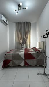a bedroom with a bed with a checkered blanket at Cantinho de paz in Santarém