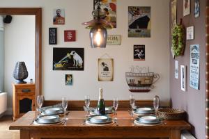 - une table en bois avec des assiettes et des verres à vin dans l'établissement Stunning House in Clanfield, à Clanfield