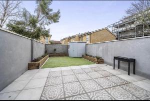 a backyard with a fence and a courtyard with a lawn at Green Gate in London