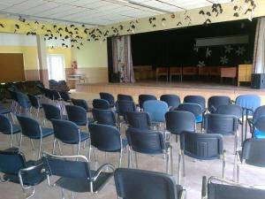 a room with blue chairs and a stage with at Remniku Holiday Centre in Remniku