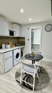 a kitchen with a table and a kitchen with a stove at Guest&Rest Elite 2 in London