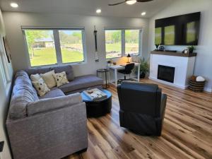 sala de estar con sofá y chimenea en Lakeside Luxury at Duck Creek on Grand Lake, Oklahoma, en Afton