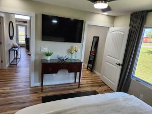 1 dormitorio con 1 cama y TV de pantalla plana en la pared en Lakeside Luxury at Duck Creek on Grand Lake, Oklahoma, en Afton