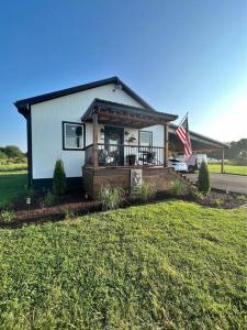 una piccola casa con un portico e una bandiera americana di Lakeside Luxury at Duck Creek on Grand Lake, Oklahoma ad Afton