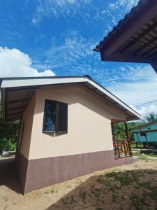 a small house with a window on the side of it at Permata Beach Chalet in Kampong Juara