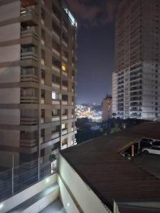 a view of two tall buildings at night at Quarto Cambuí l Apto compartilhado in Campinas