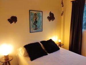 1 dormitorio con 1 cama, 2 lámparas y una pintura en Humboldt en Buenos Aires