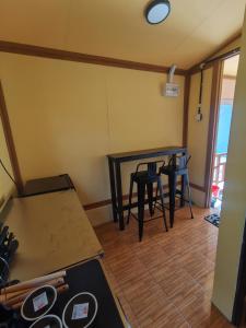 a room with two tables and two stools at Permata Beach Chalet in Kampong Juara