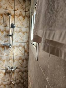 y baño con ducha y ventana. en Résidence Élisabeth en Fondjomékwet