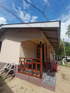 a small house with a porch and a red chair at Permata Beach Chalet in Kampong Juara