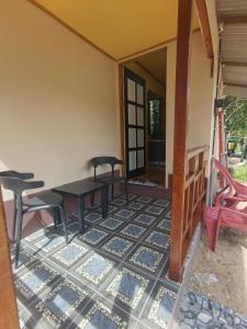 a room with a table and chairs on a patio at Permata Beach Chalet in Kampong Juara